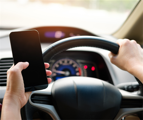 person driving while holding a cell phone